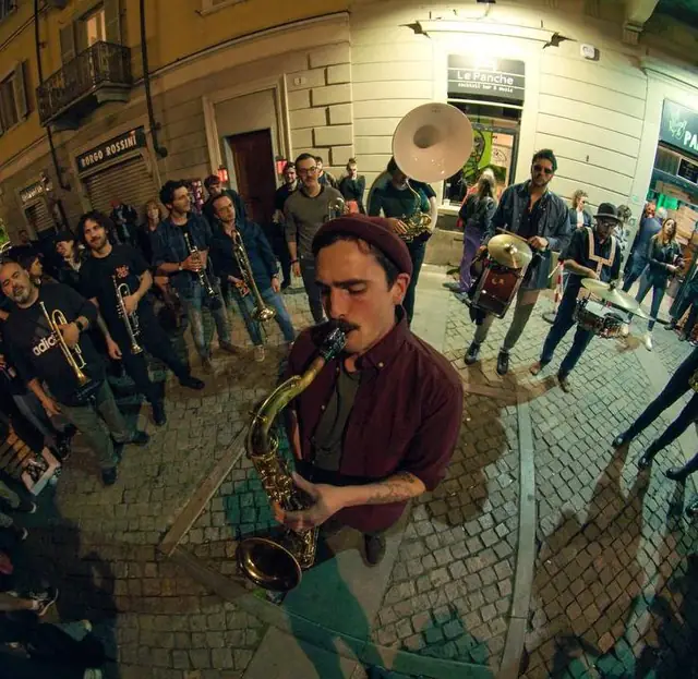Banda di ottoni che suona in mezzo ai tavolini