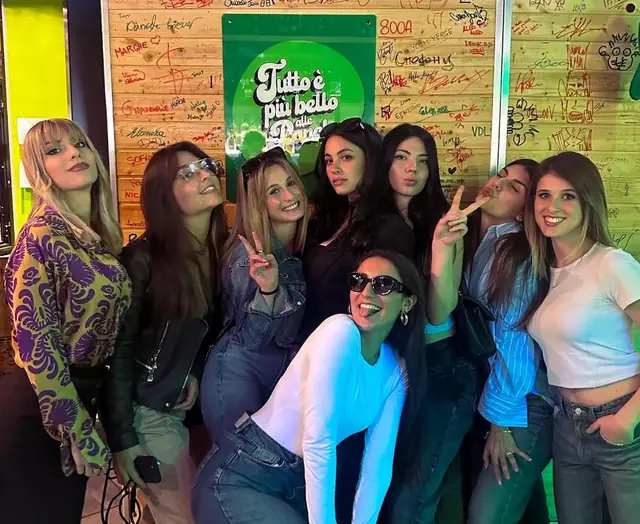 Gruppo di ragazze davanti al muro delle firme