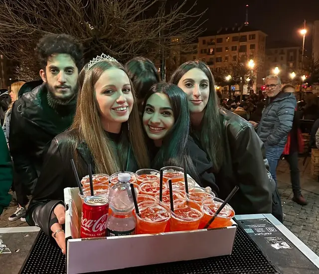 Amici con la corona d’alloro intorno a un vassoio di spritz