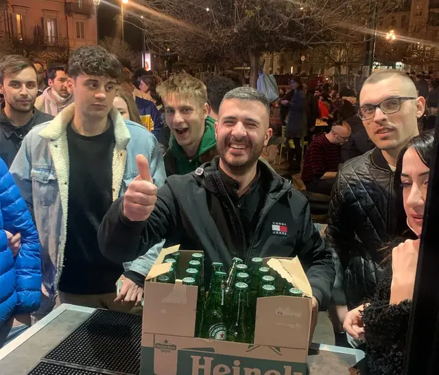 Festa con casse di birra e vassoi davanti al locale