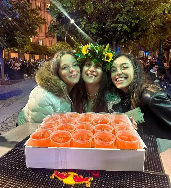 Amiche con corone di fiori e un vassoio di spritz