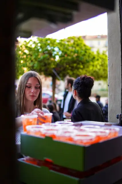Ragazza seduta dietro un vassoio di spritz