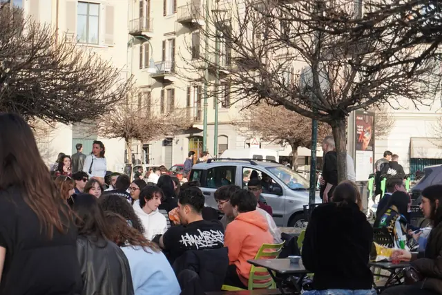 Folla sotto gli alberi della piazzetta