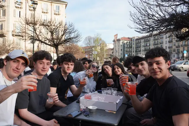 Amici a un tavolo che salutano verso l’obiettivo