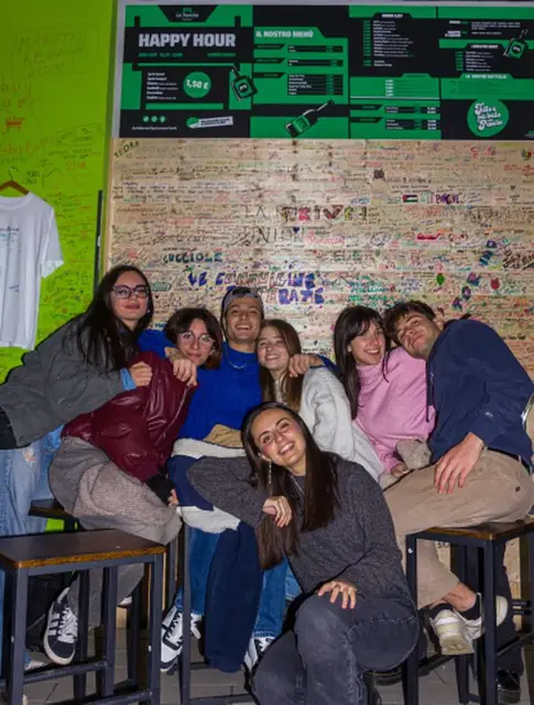 Gruppo seduto davanti al muro delle firme a Bologna