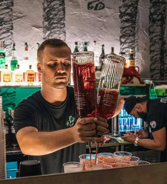 Il barista alza due spritz dietro il bancone