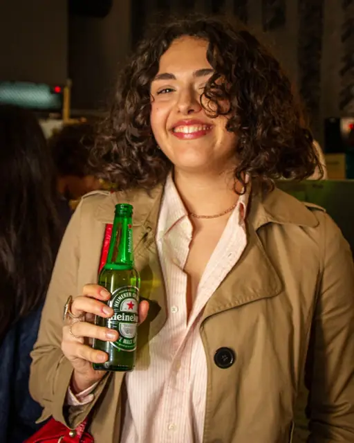 Ragazza sorridente con una bottiglia di birra