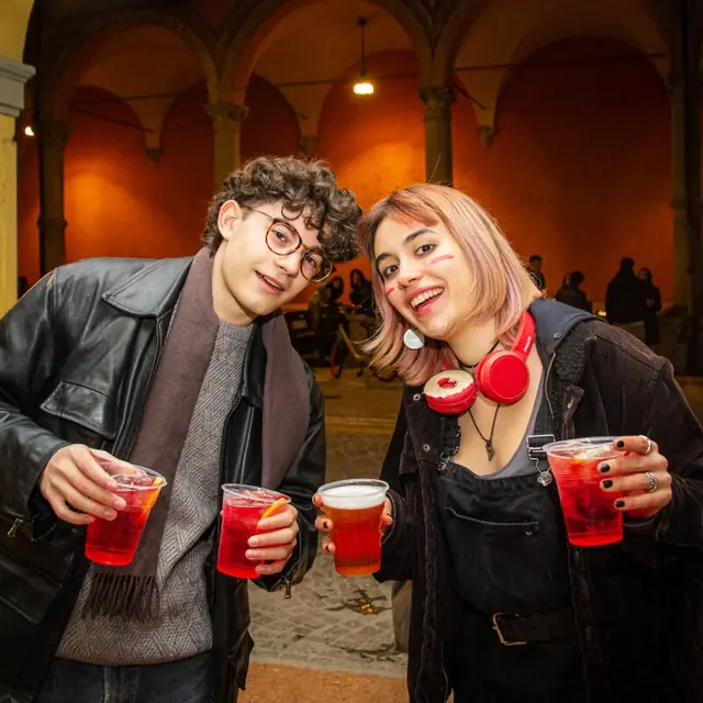 Due amici con i bicchieri rossi sotto il portico